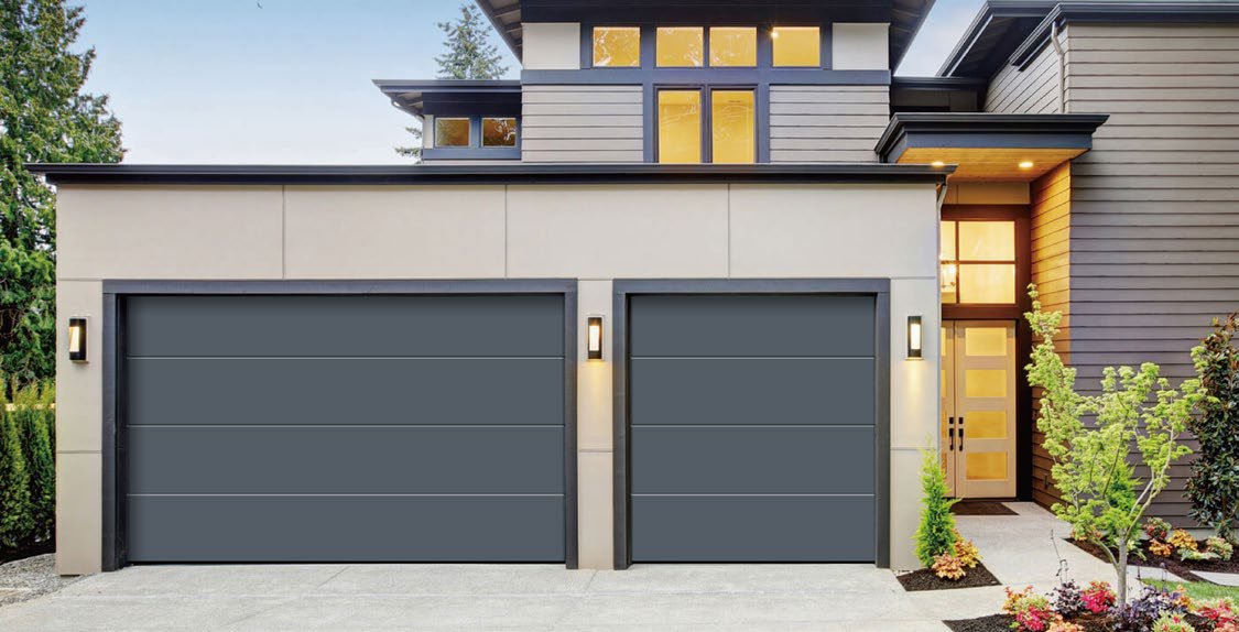 Pair of charcoal flat-panel garage doors with slim reveal lines on a modern home