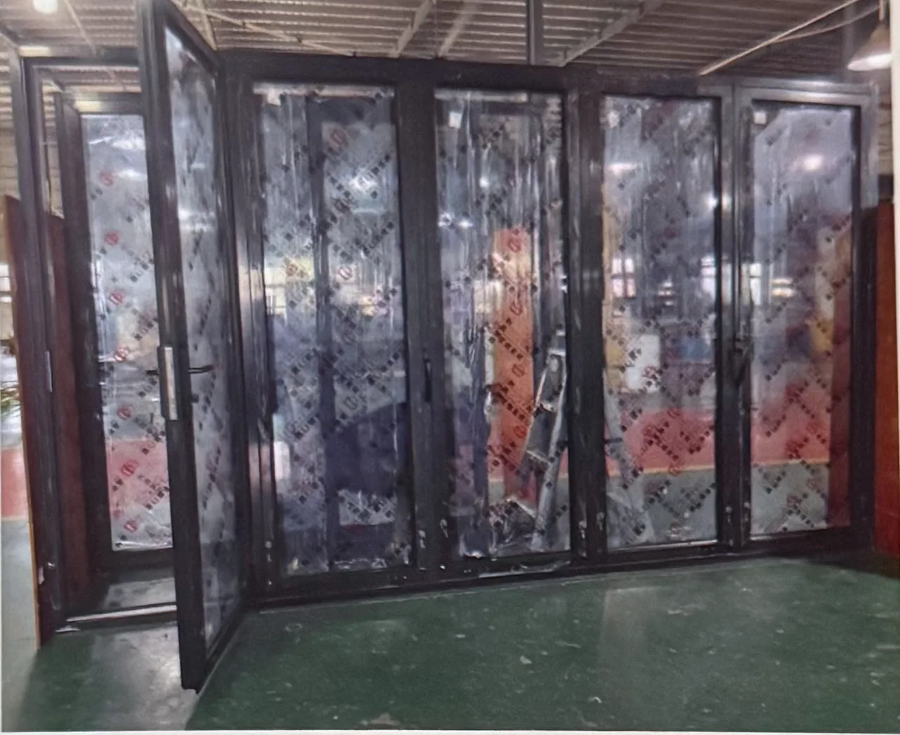 Dark-framed multi-panel bi-fold door with textured glass, shown partly folded open