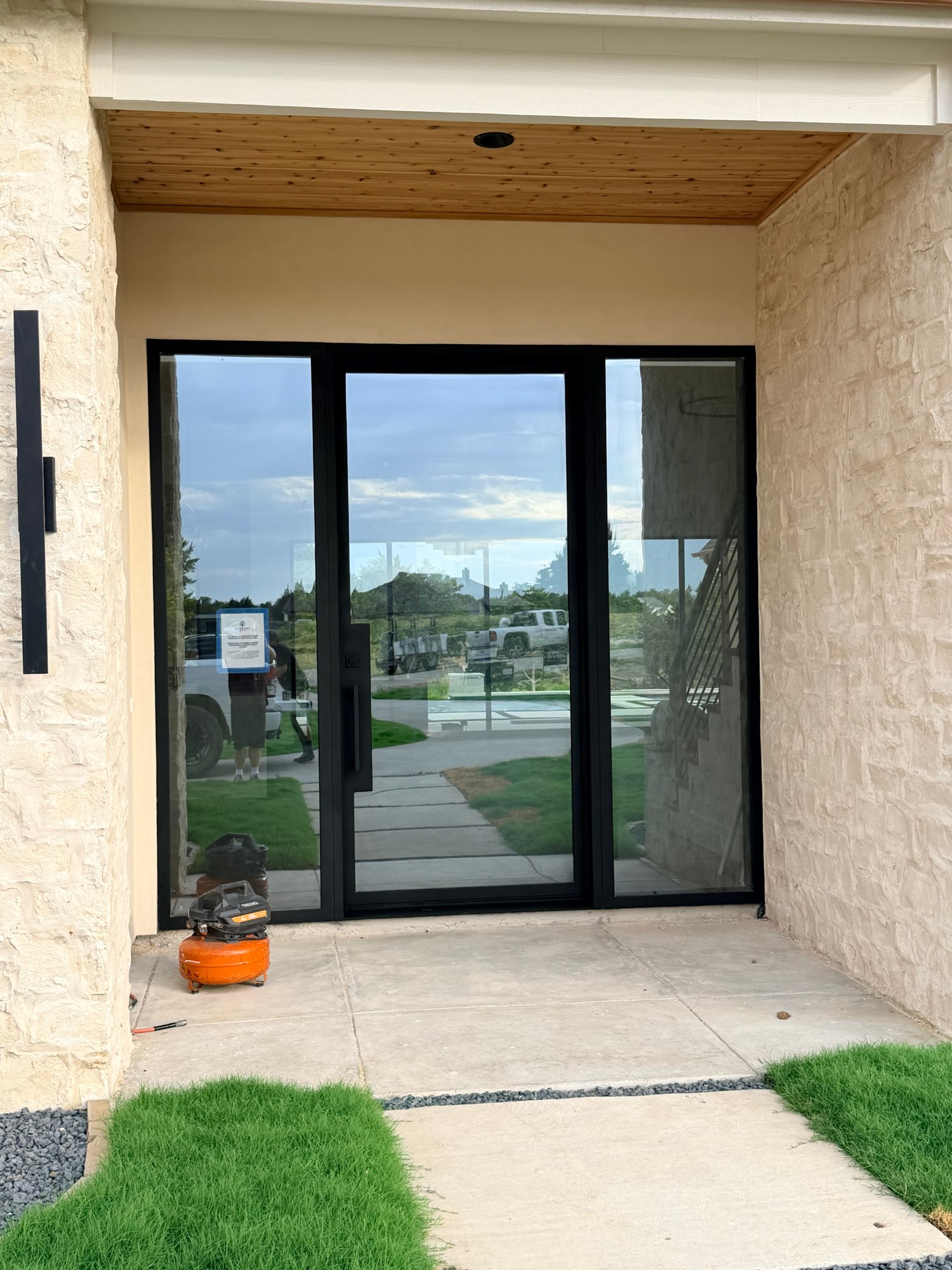 Glass double entry beneath a covered porch
